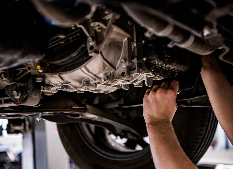 image of mechanic underneath a car at Masaki's automotive